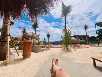 a person laying on a towel on a beach