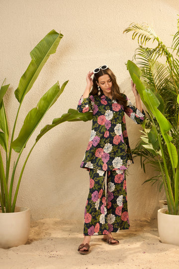 Woman in floral outfit standing among tropical plants