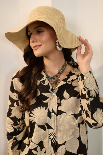 Woman wearing a wide-brimmed hat and floral shirt