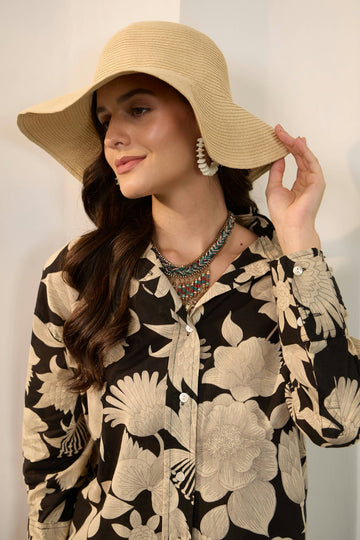Woman wearing a wide-brimmed hat and floral shirt
