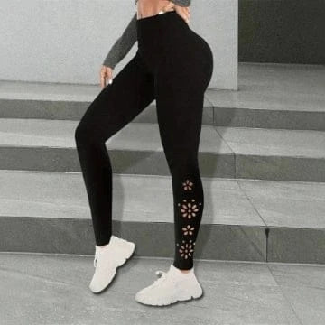 Person wearing black leggings with floral cutouts on a gray stone staircase.